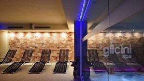 A spa area with lounge chairs and a glass wall. - Hotel Villa Glicini (San Secondo di Pinerolo)