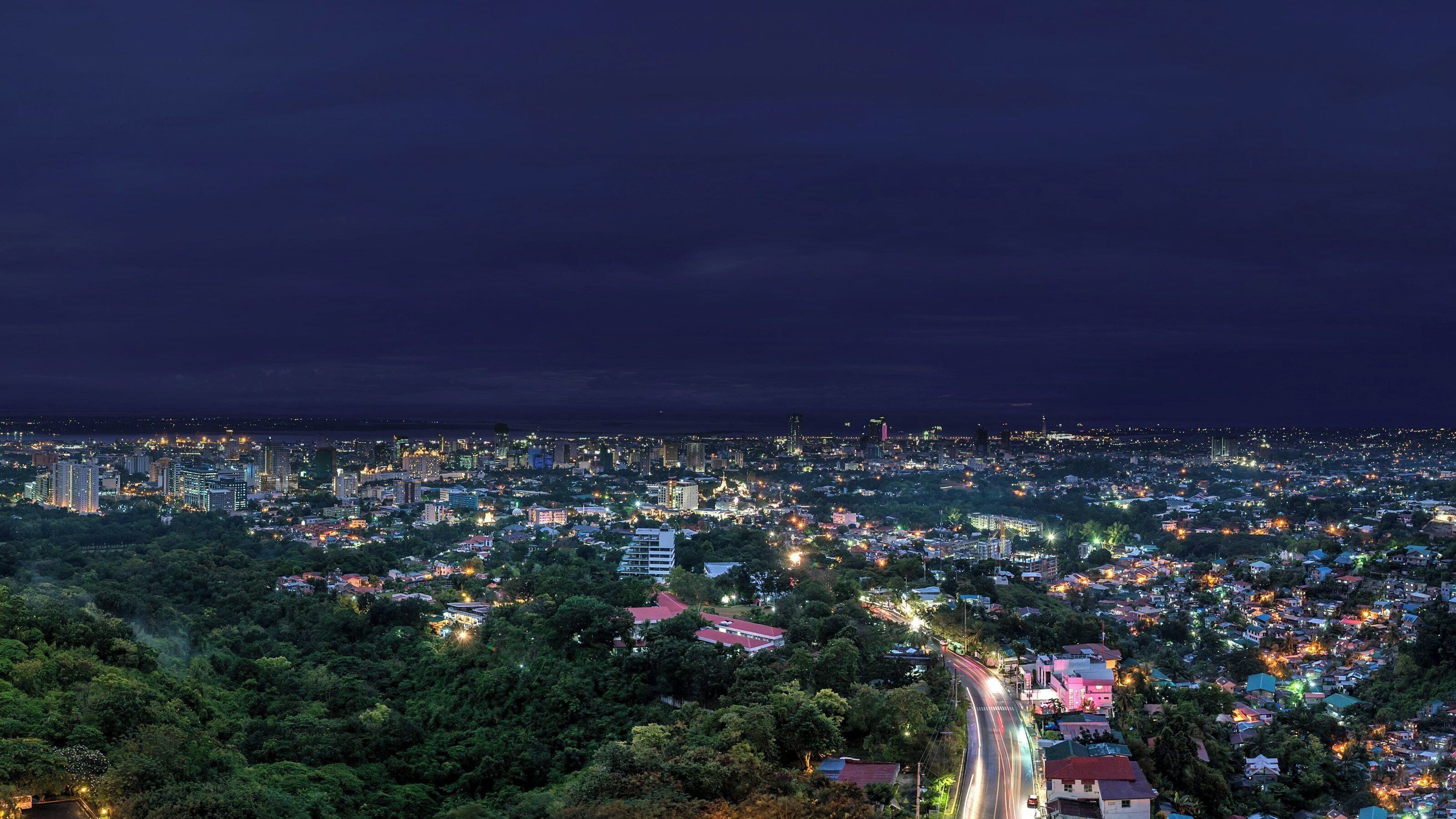 A nighttime cityscape with dense urban development and a mix of residential and commercial buildings.
