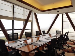 A conference room with a long table, multiple chairs, and large windows with blinds. - Marco Polo Plaza Cebu (Cebu City)