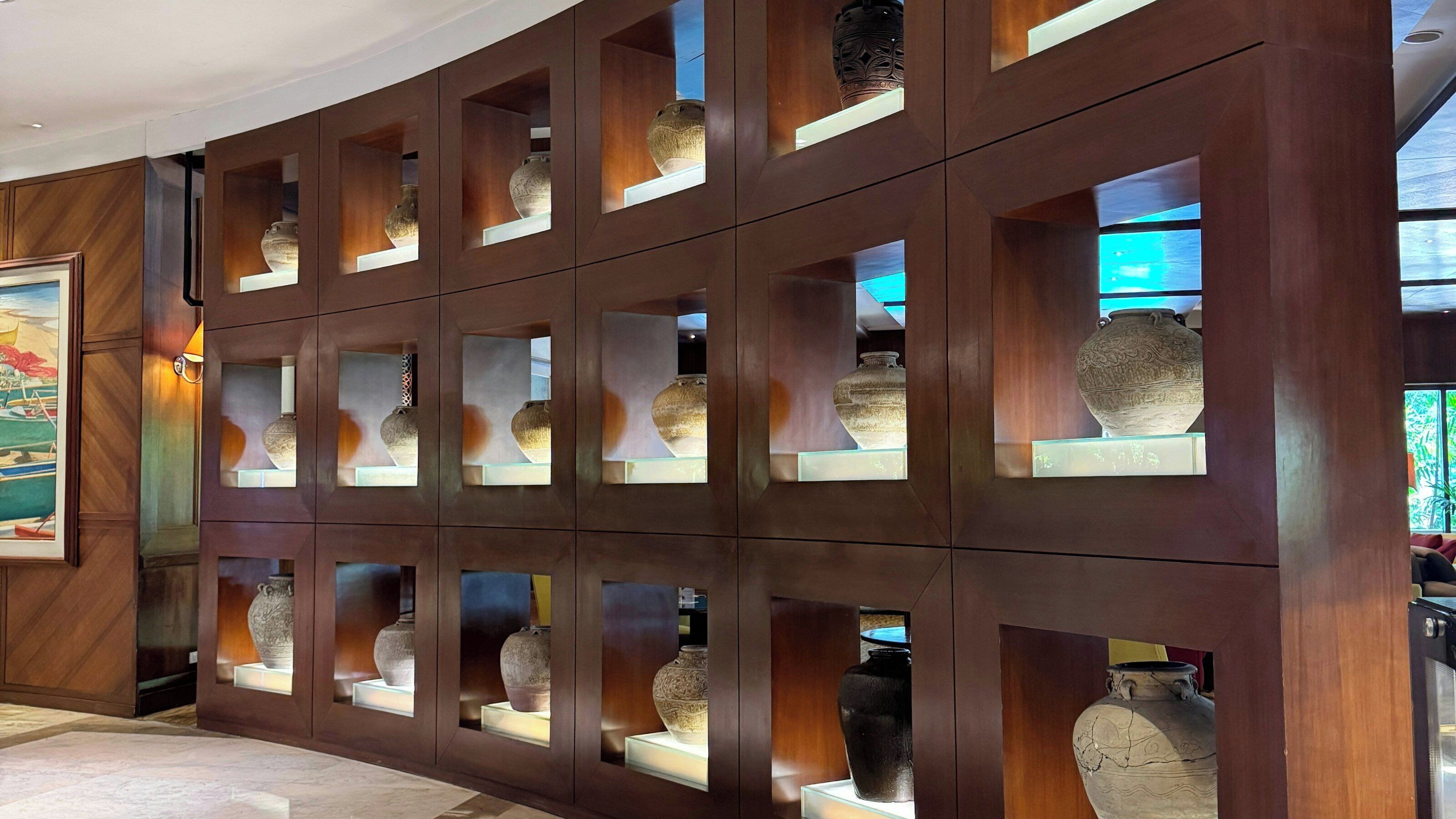 A wall with multiple display cases containing various pottery items.