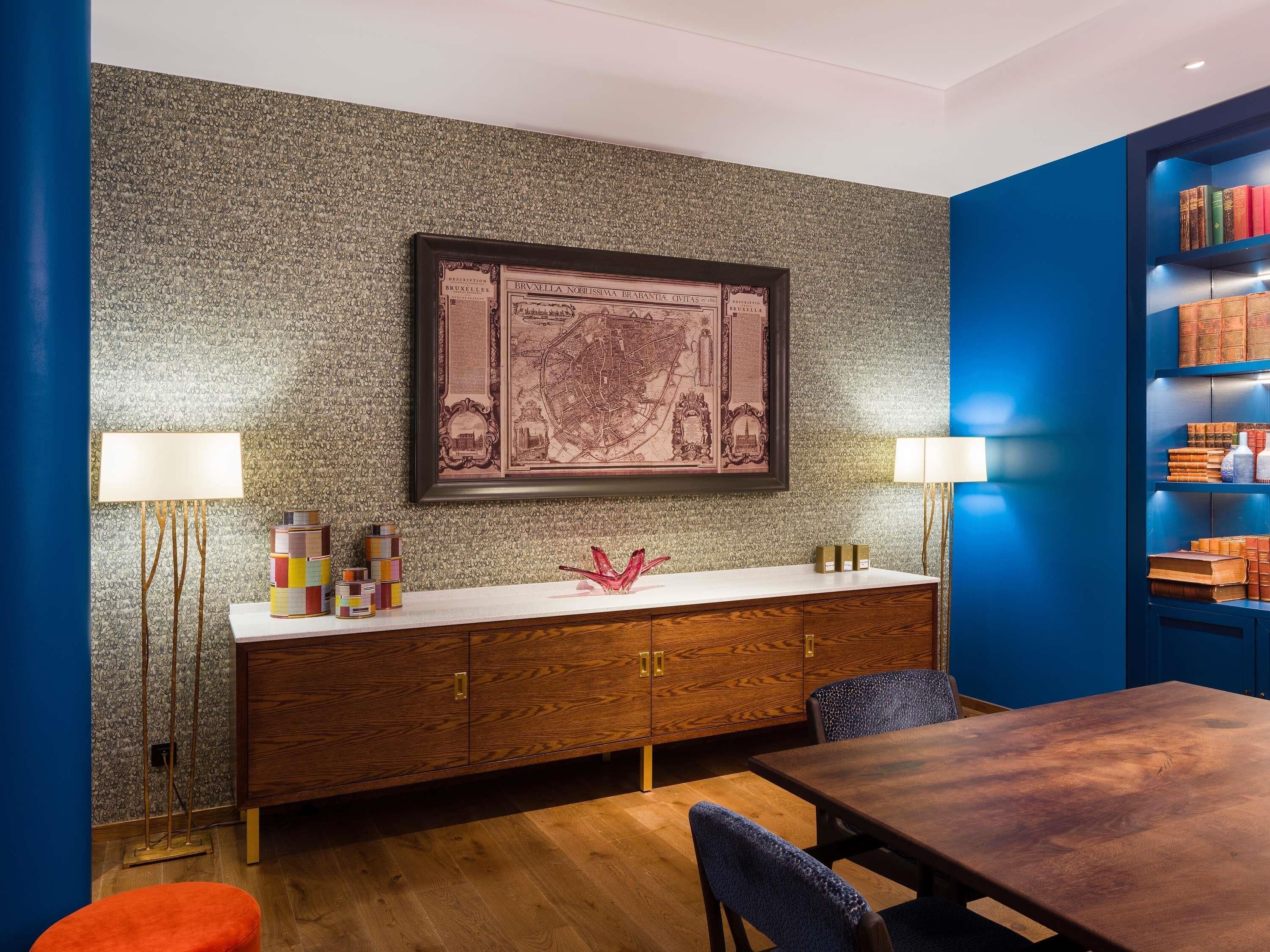 A modern room with a wooden cabinet, a framed map, and a bookshelf.