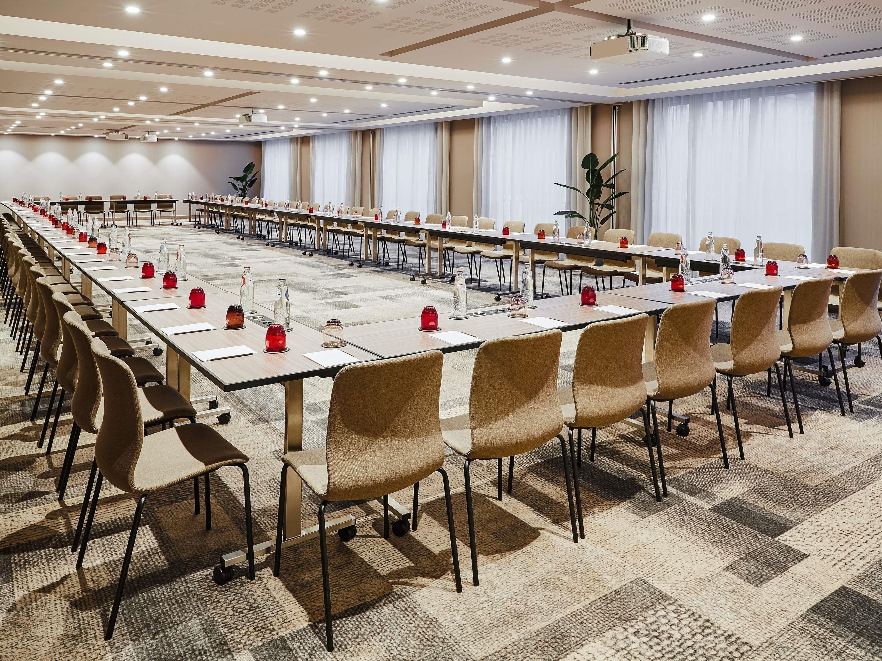 Une salle de conférence équipée d’une longue table, de chaises et d’un projecteur.