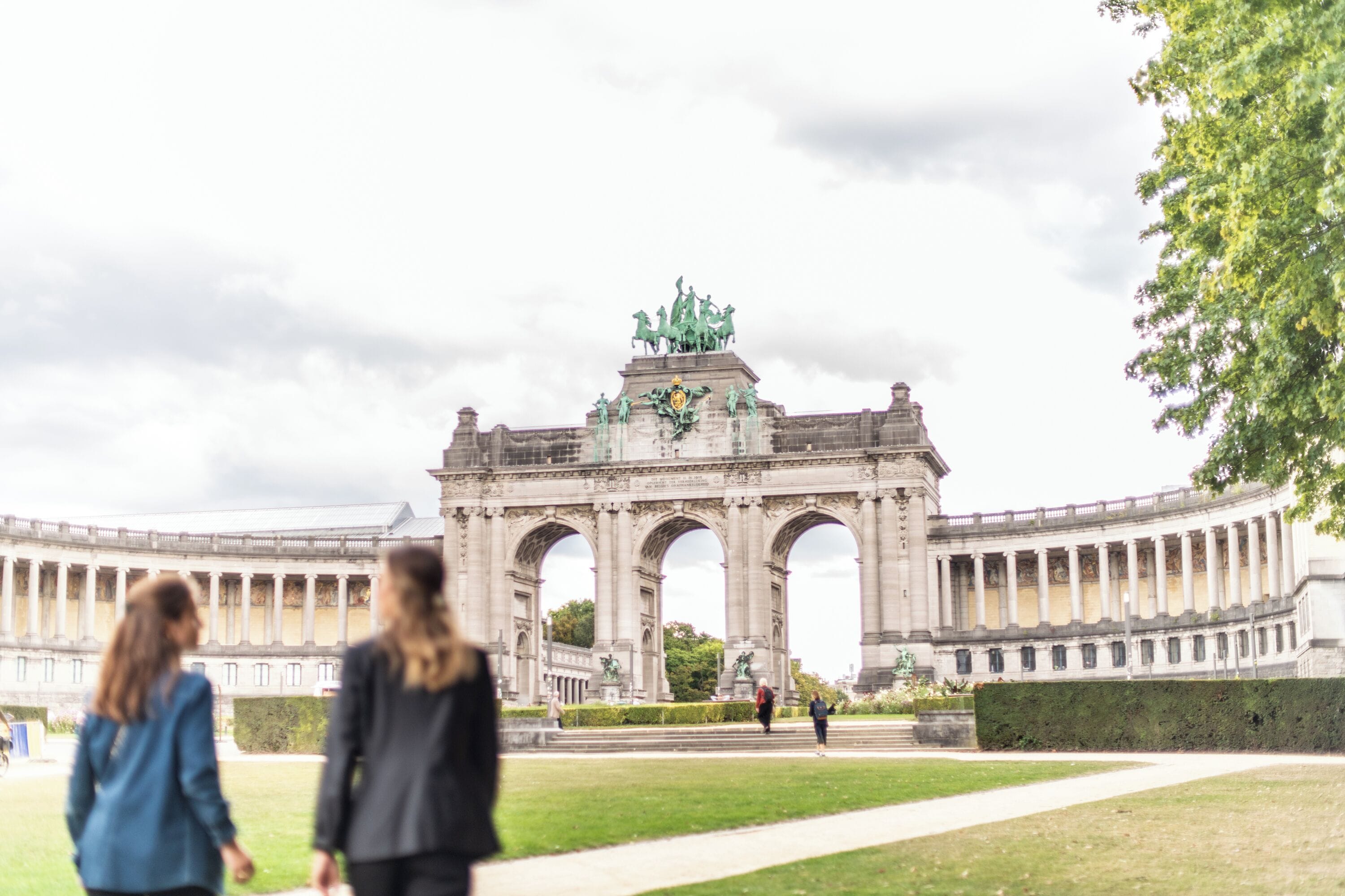 A large, historic building with a central archway and statues.