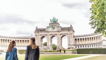 A large, historic building with a central archway and statues.