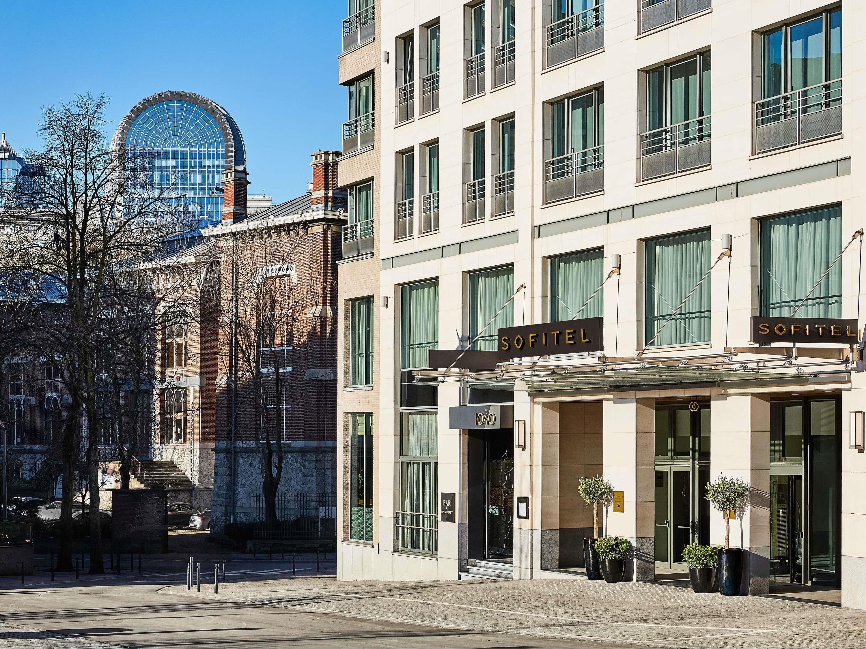 Un hôtel à la façade moderne, doté de grandes fenêtres et d’une enseigne indiquant « SOFITEL ».