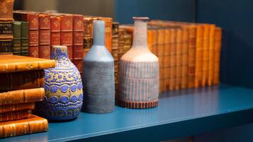 A collection of books and decorative vases on a shelf.