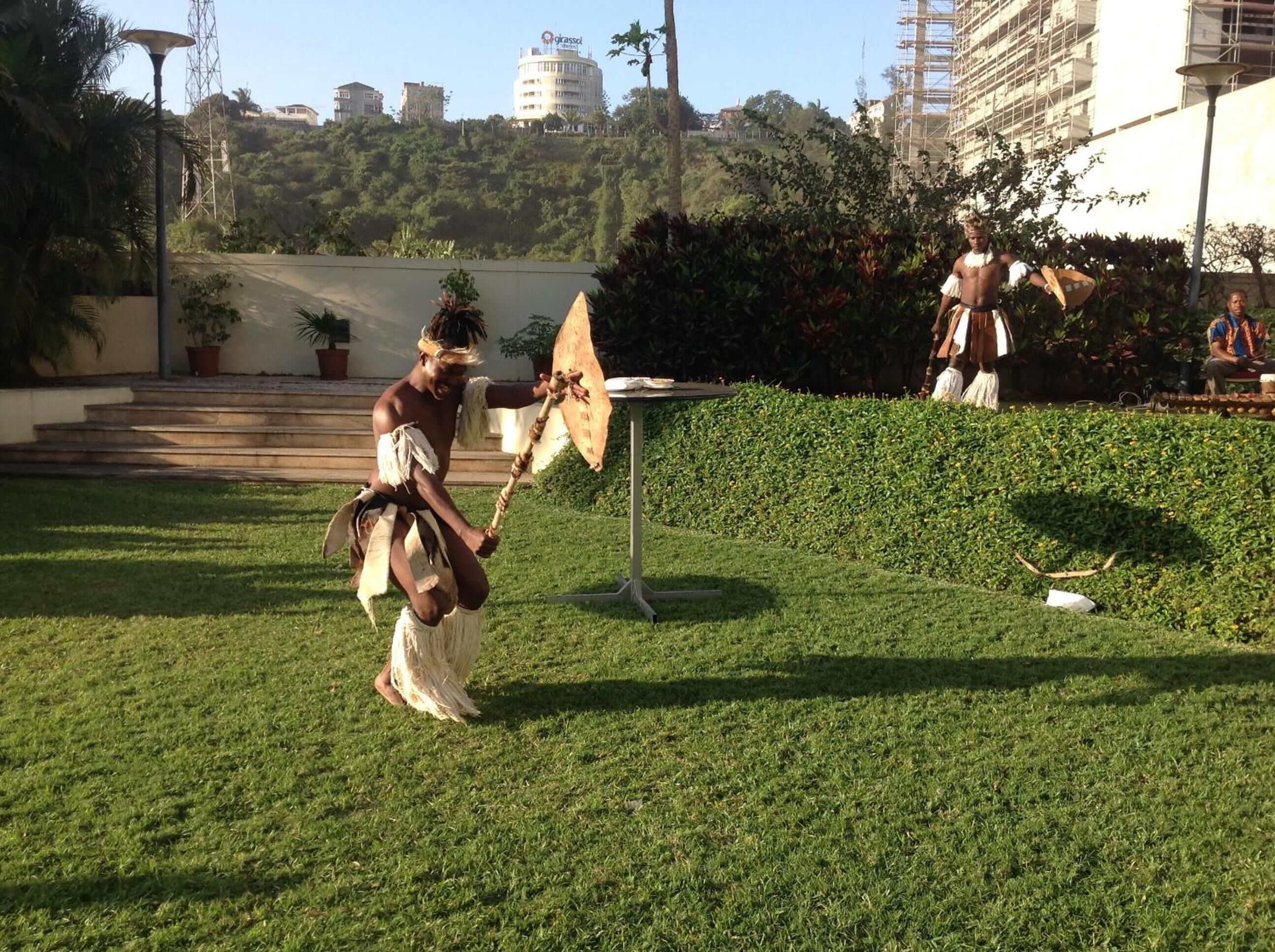 A grassy outdoor area with a table and steps leading up to a building.
