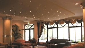 A spacious lobby with a large seating area, a coffee table, and a potted plant. - VIP Grand Maputo (Maputo)