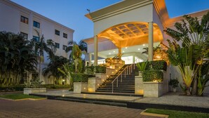 A modern hotel entrance with a covered staircase, palm trees, and a well-lit pathway. - VIP Grand Maputo (Maputo)