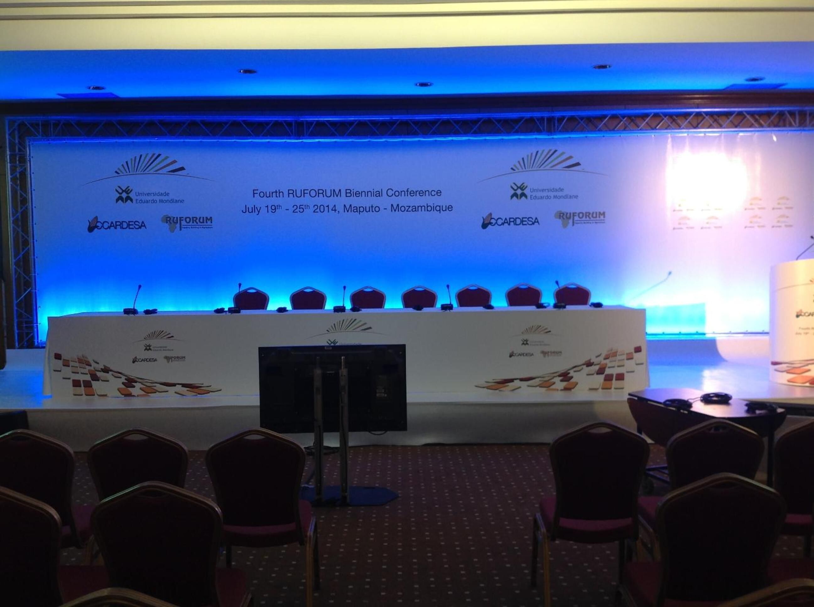 A conference room with a stage, chairs, and a podium.