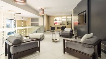 A modern living room with a sofa set, a coffee table, and a TV mounted on the wall.
