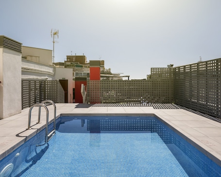 Outdoor pool, sun loungers. Hotel ILUNION Auditori