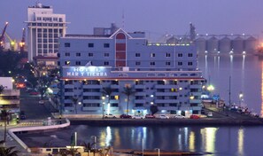 Un hôtel avec une enseigne bien visible indiquant « HÔTEL MAR Y TIERRA », situé au bord de l’eau.