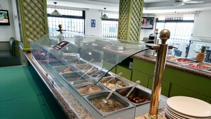Een buffetgedeelte met diverse voedingsopties en een fruitschaal.