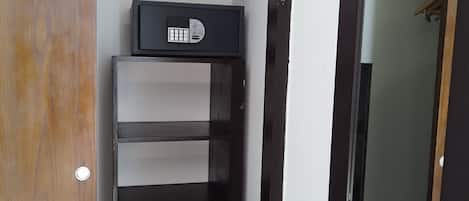 Un armadio con un mobile contenitore nero, ripiani e una barra appendiabiti.