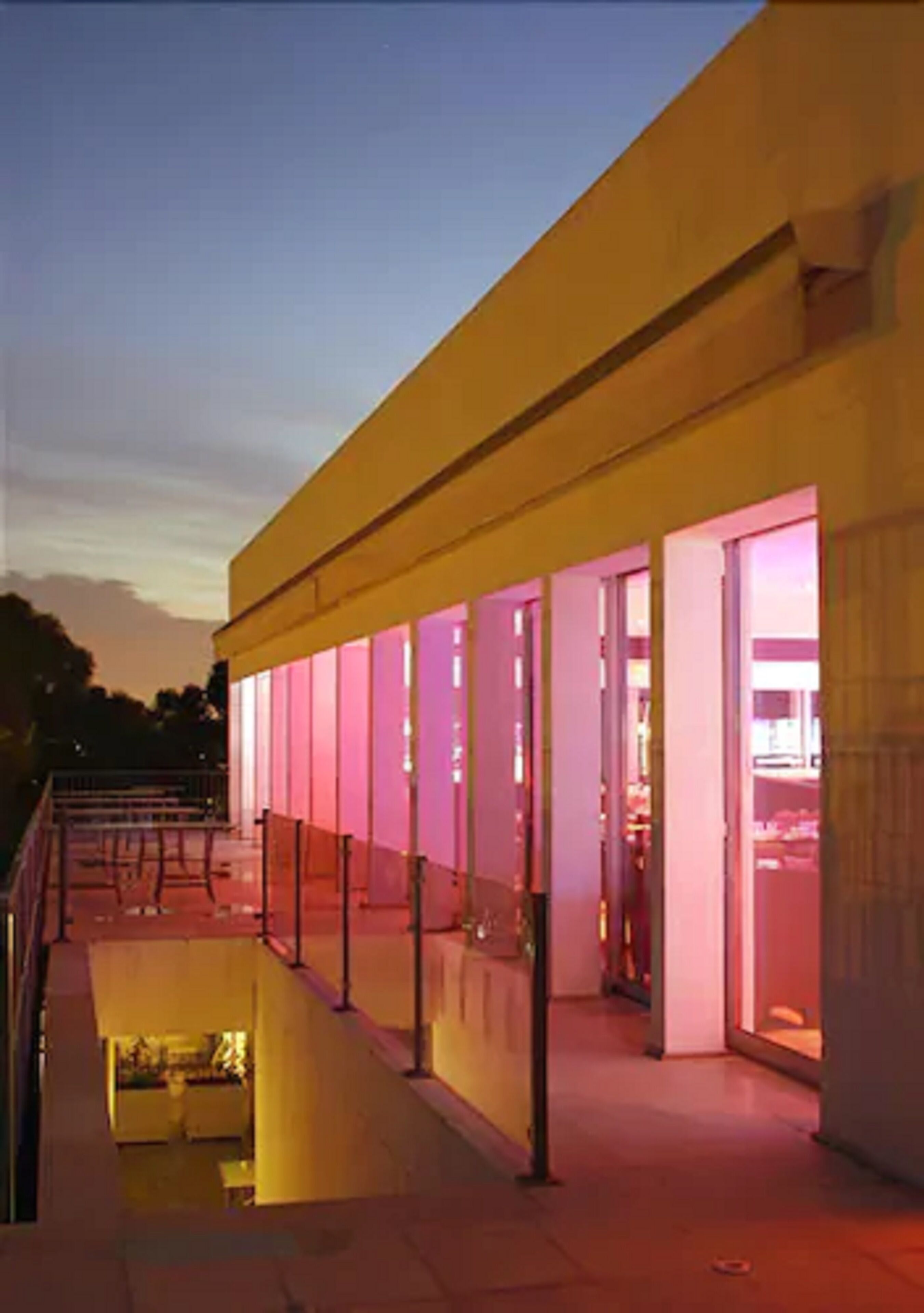 A modern building with a long, covered walkway and large windows.