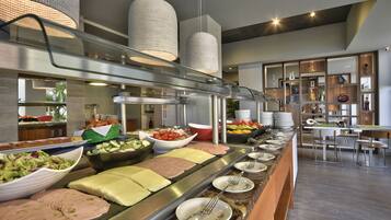 Een buffetopstelling met diverse gerechten, een zithoek en een modern interieur.