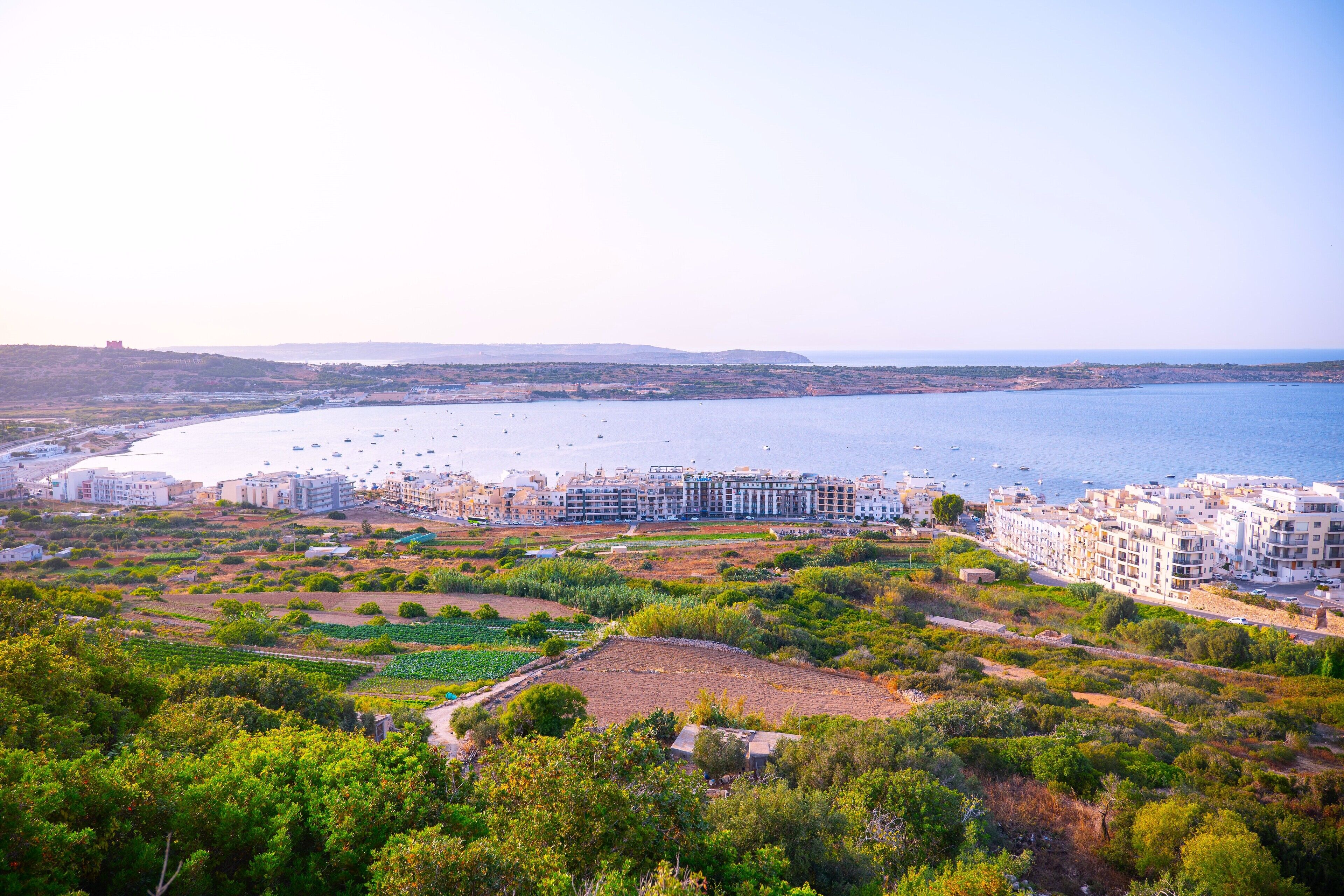 A coastal town with a marina, residential buildings, and green spaces.
