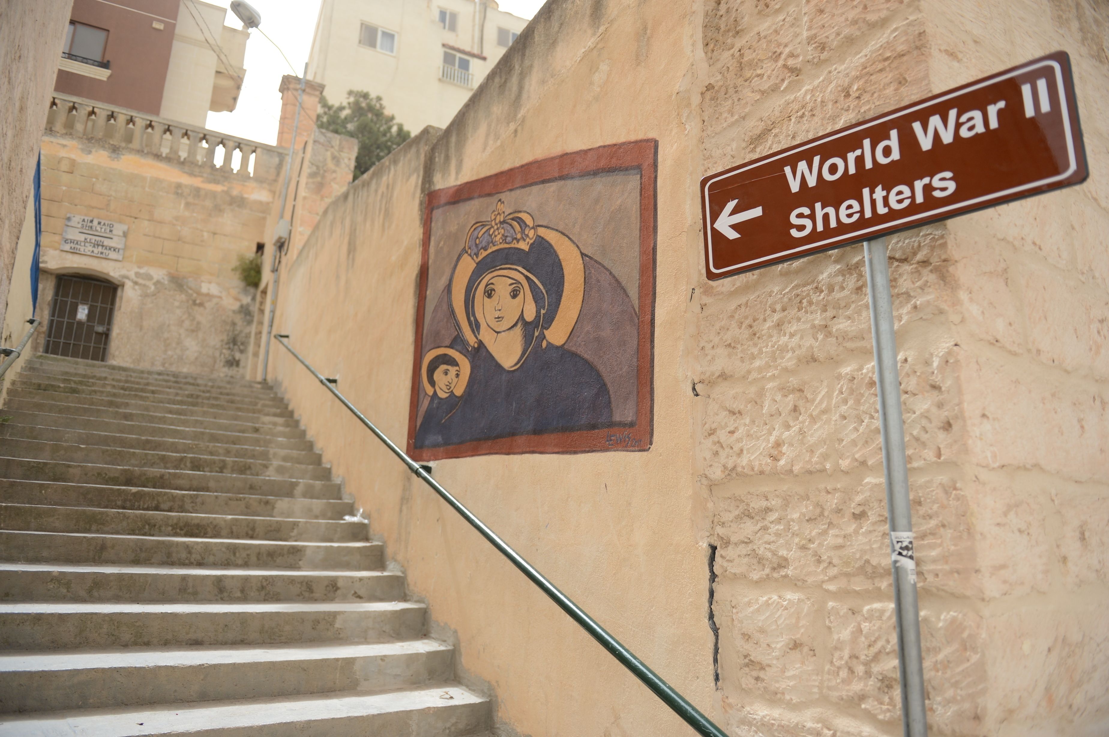 A staircase leading to a building with a sign indicating World War II shelters.