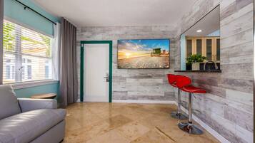 Suite Supérieure, 1 trÚs grand lit, cuisine, vue ville | Coin séjour | TV connectée de 65 pouces avec chaßnes par satellite, télévision
