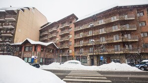 A multi-story hotel with balconies, a pedestrian crossing, and a snow-covered street. - Hotel Marco Polo by Nexta (La Massana)