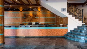 A reception area with a marble counter, a sign for 'Bar Sala de Jocs', and a staircase with a wrought iron railing. - Hotel Marco Polo by Nexta (La Massana)