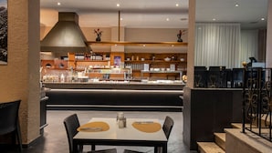 A restaurant with a bar area, seating, and a view of the street. - Hotel Marco Polo by Nexta (La Massana)