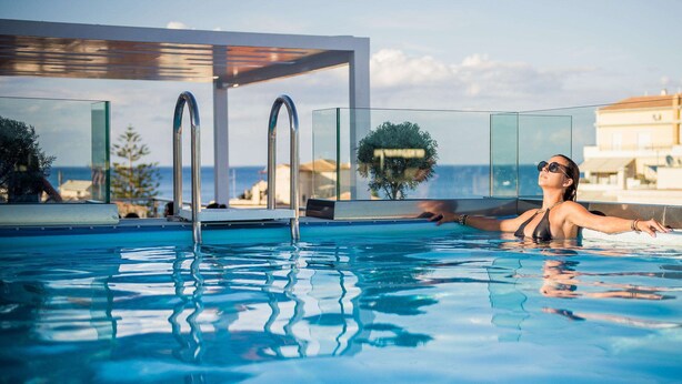 A pool with clear water, a modern design, and a view of the sea. - Diana Hotel (Zakynthos)
