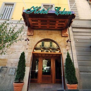 A hotel entrance with a wooden archway and a sign above it.