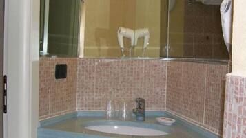 A bathroom with a sink, mirror, and a towel rack.