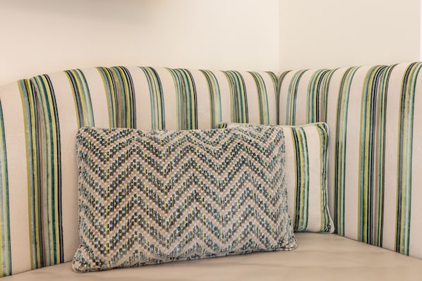 Un sofá con tapicería a rayas y un cojín decorativo estampado.