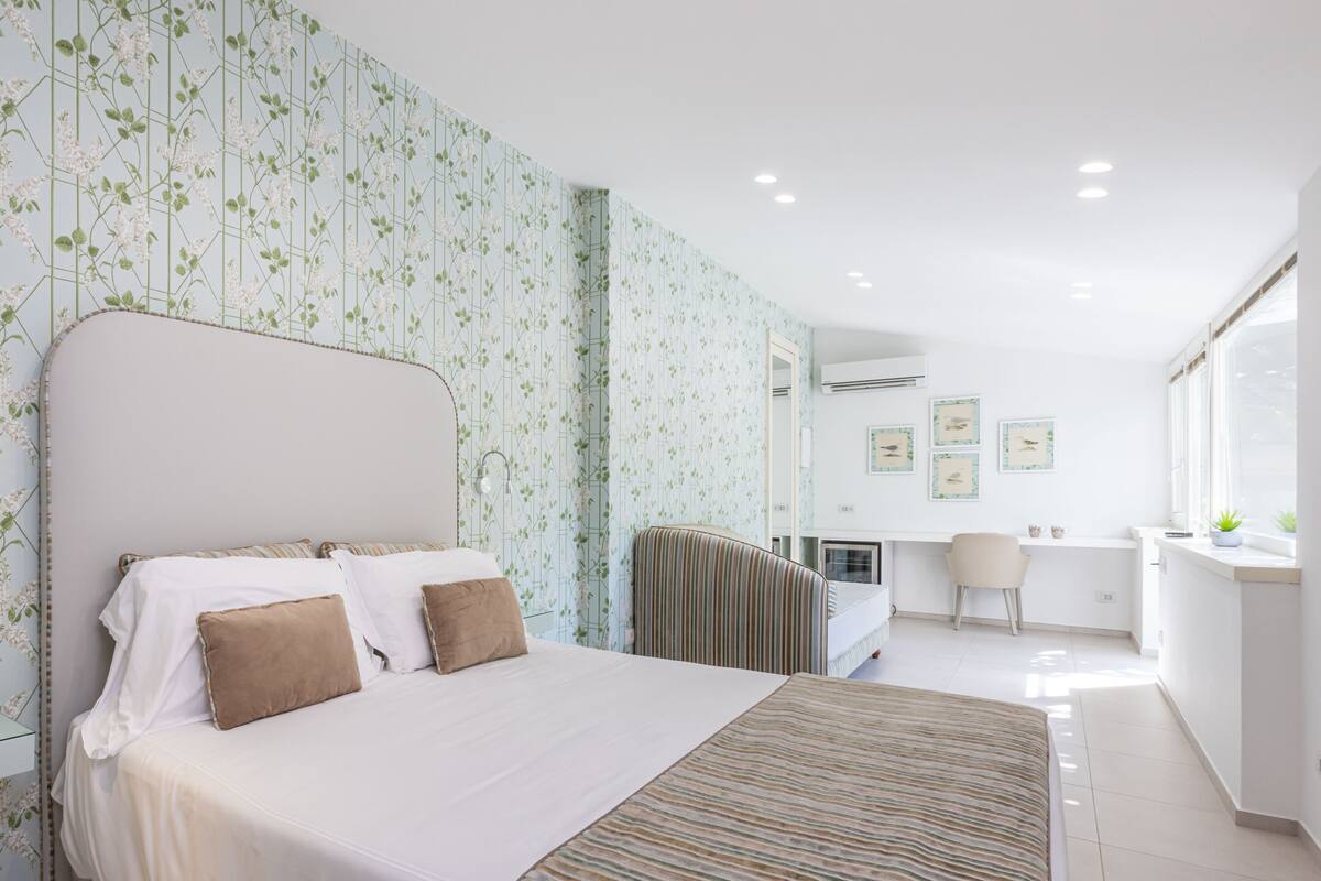 Una habitación de hotel moderna con una cama grande, un escritorio y una ventana.