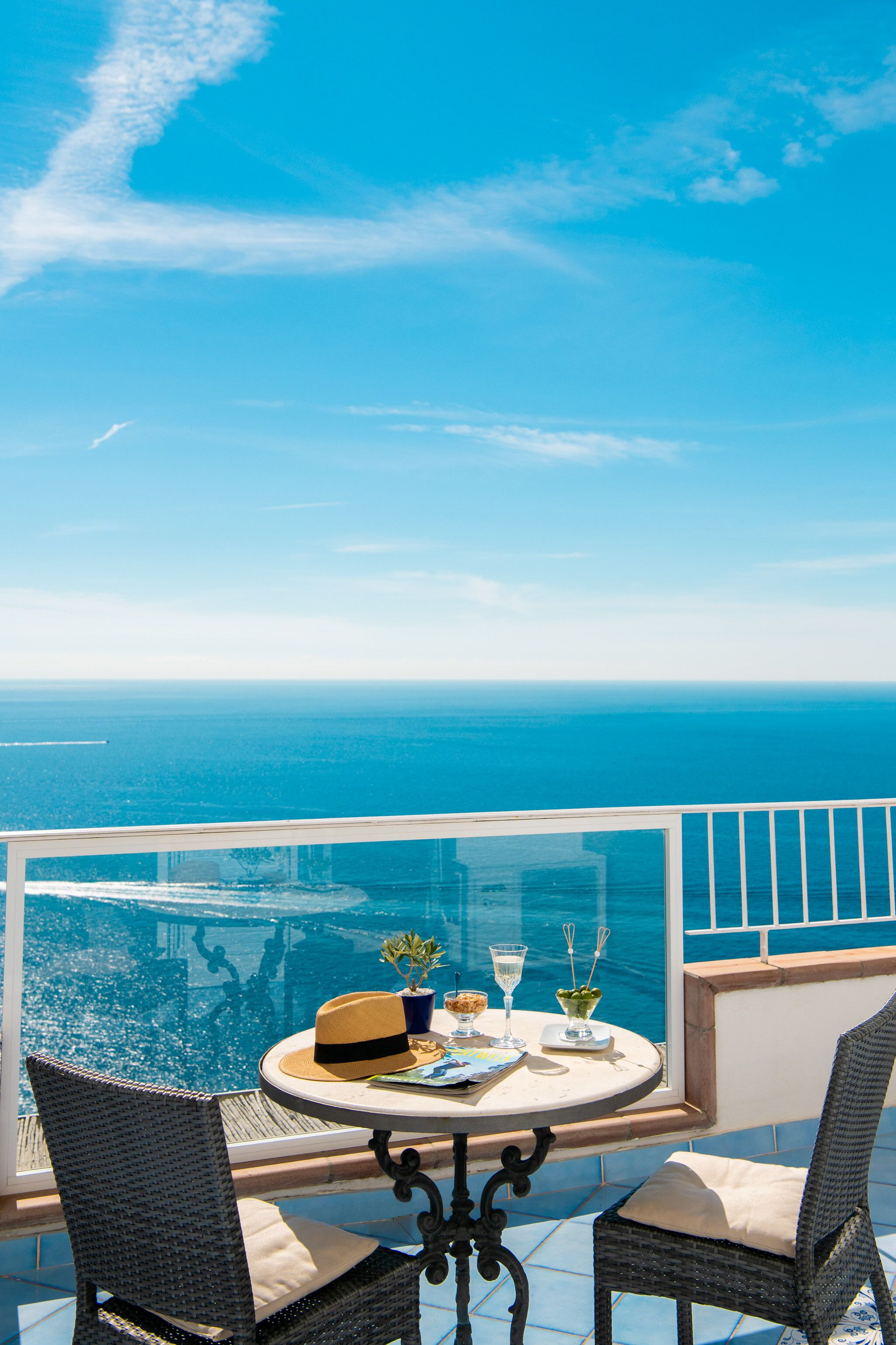Ein Balkon mit Tisch für zwei Personen, mit Blick auf ein Gewässer.