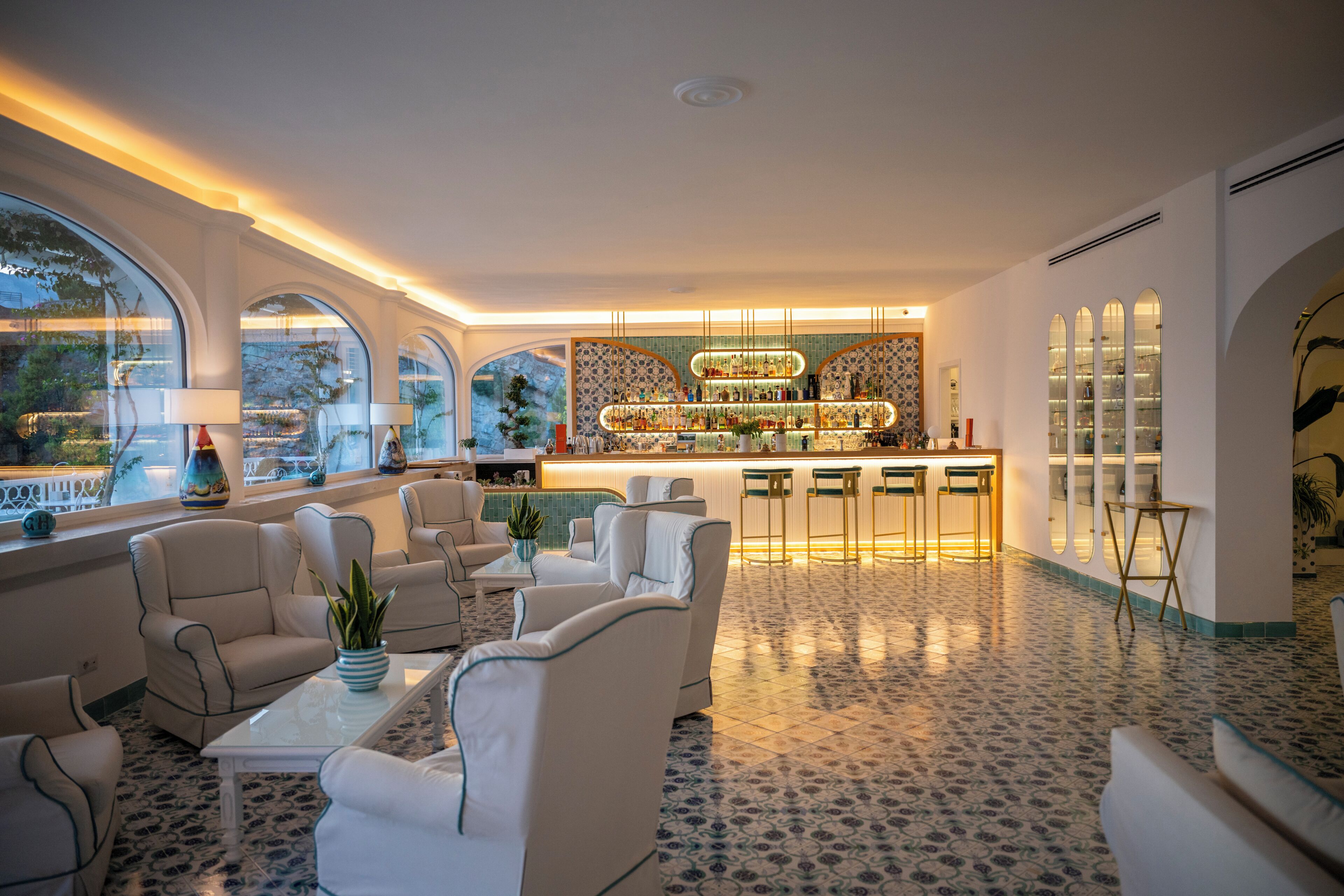 A spacious lounge with a bar area, comfortable seating, and large windows.