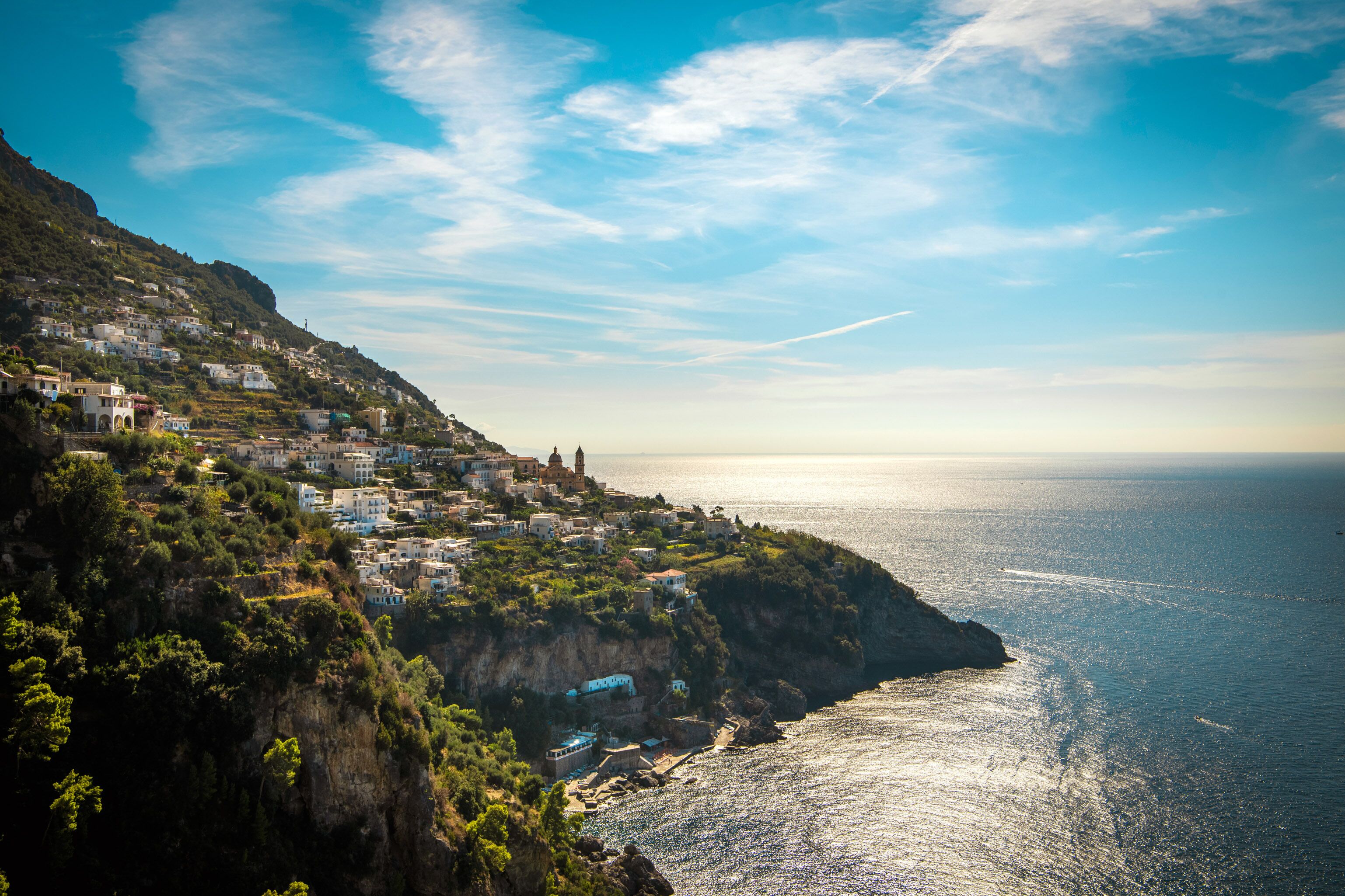 A coastal town with buildings on a hillside overlooking the sea.