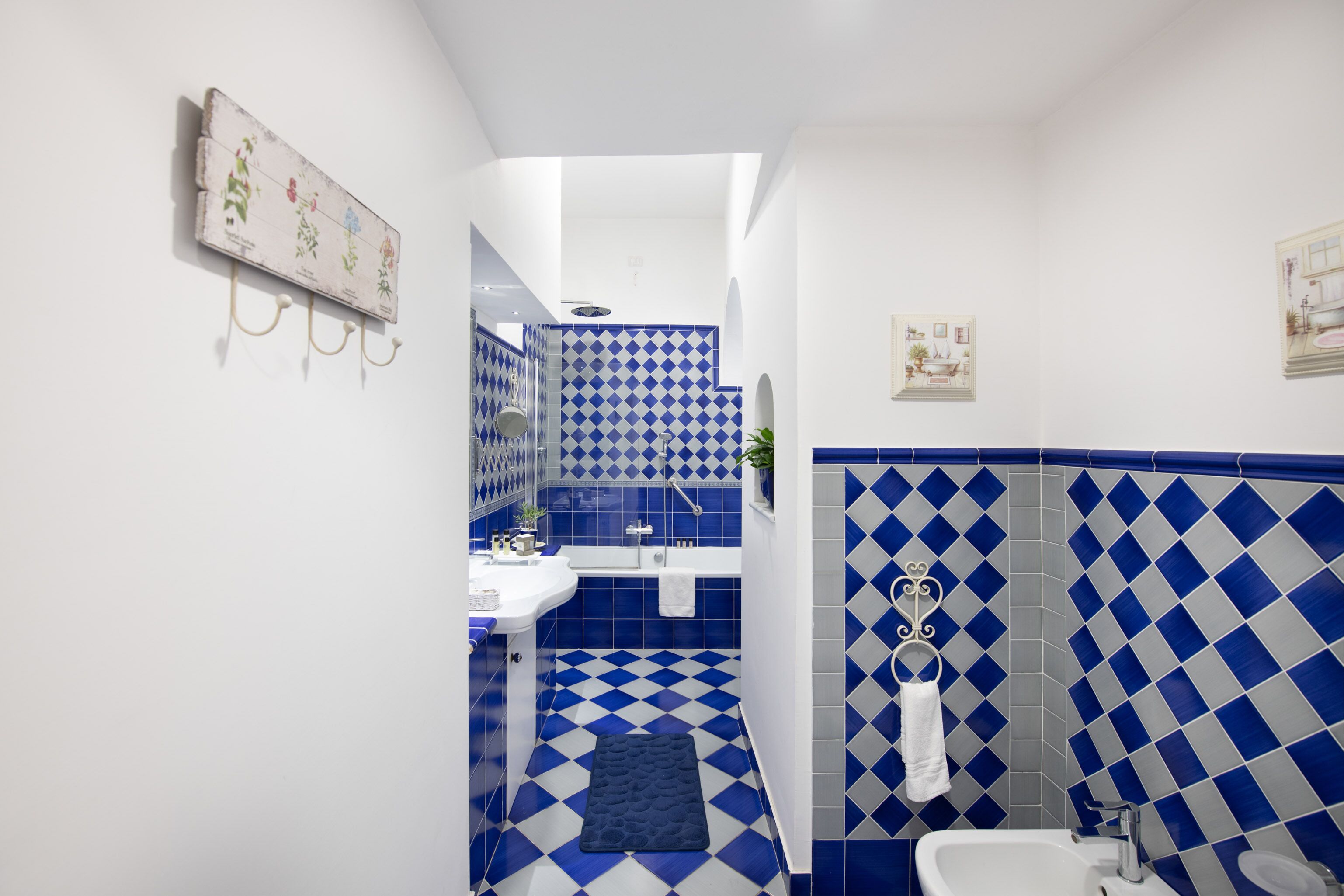 A bathroom with a blue and white checkered floor, a white sink, and a white toilet.