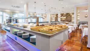 A buffet area with a variety of food items, a seating area with tables and chairs, and a modern interior design. - Mirachoro Carvoeiro (Lagoa)