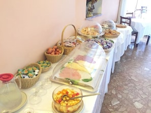 A buffet table with various food items and baskets. - Hotel Mediterranee (Taormina)