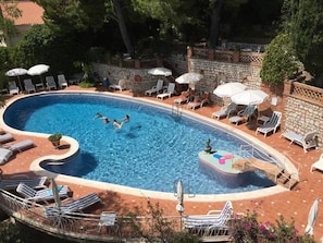 Outdoor pool, open 9 AM to 6 PM, pool umbrellas, pool loungers