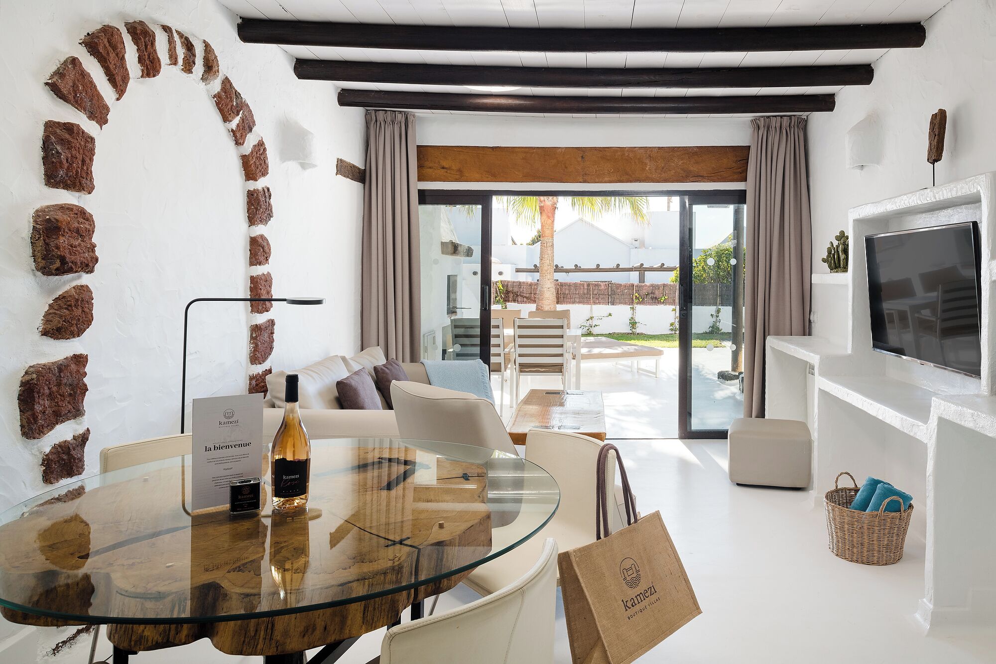 A modern living room with a glass table, a sofa, and a TV.