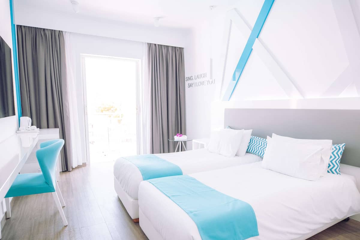 Une chambre d’hôtel moderne, dotée d’un grand lit, d’un bureau et d’une chaise.