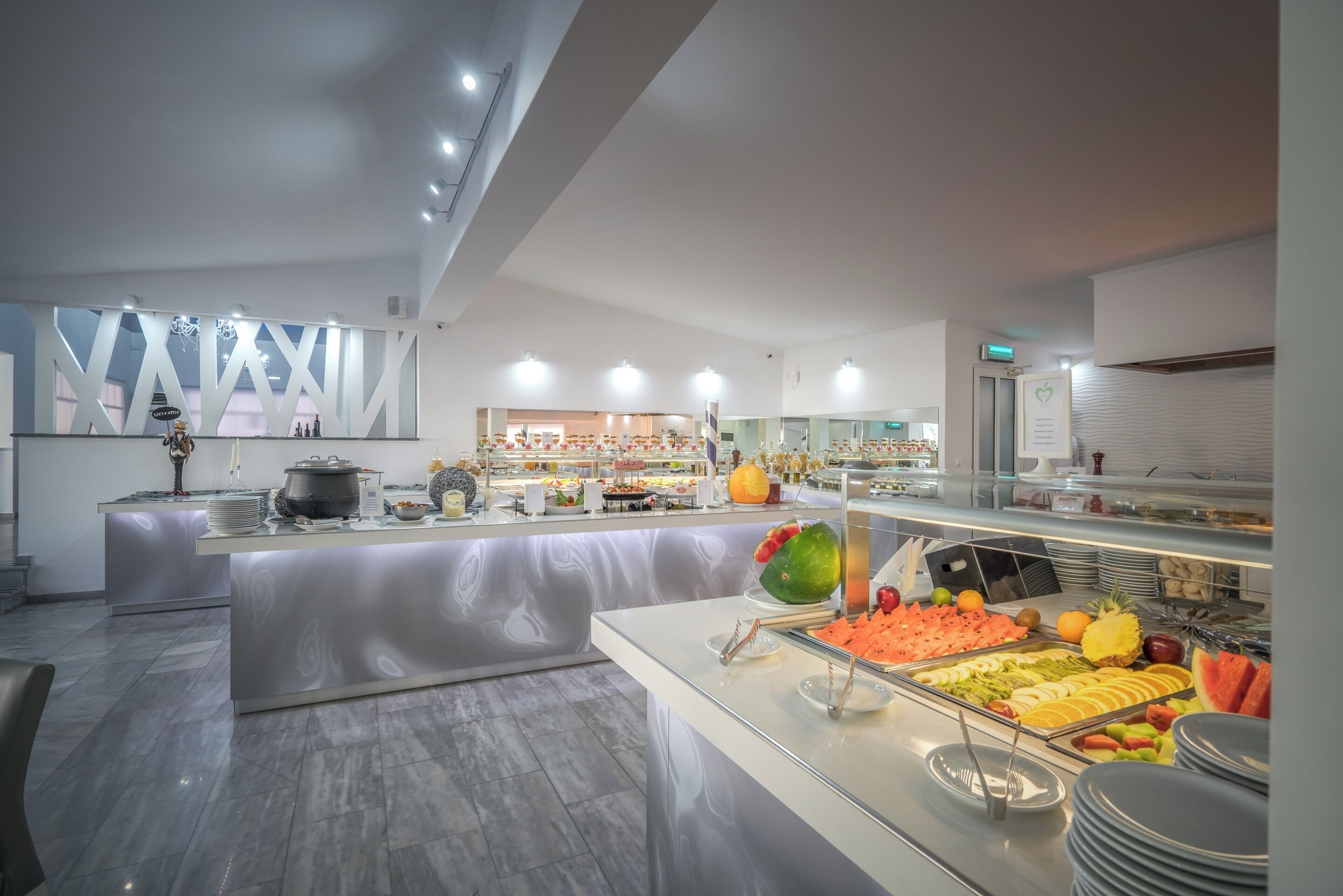 Een modern hotelbuffet met diverse gerechten, een centraal eiland en een strak, eigentijds design.