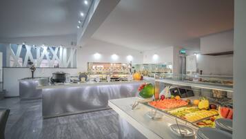 Een modern hotelbuffet met diverse gerechten, een centraal eiland en een strak, eigentijds design.