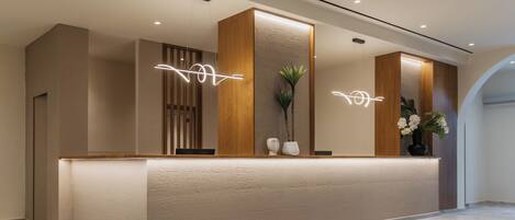 A reception desk with a textured wall, wooden paneling, and a geometric patterned floor.
