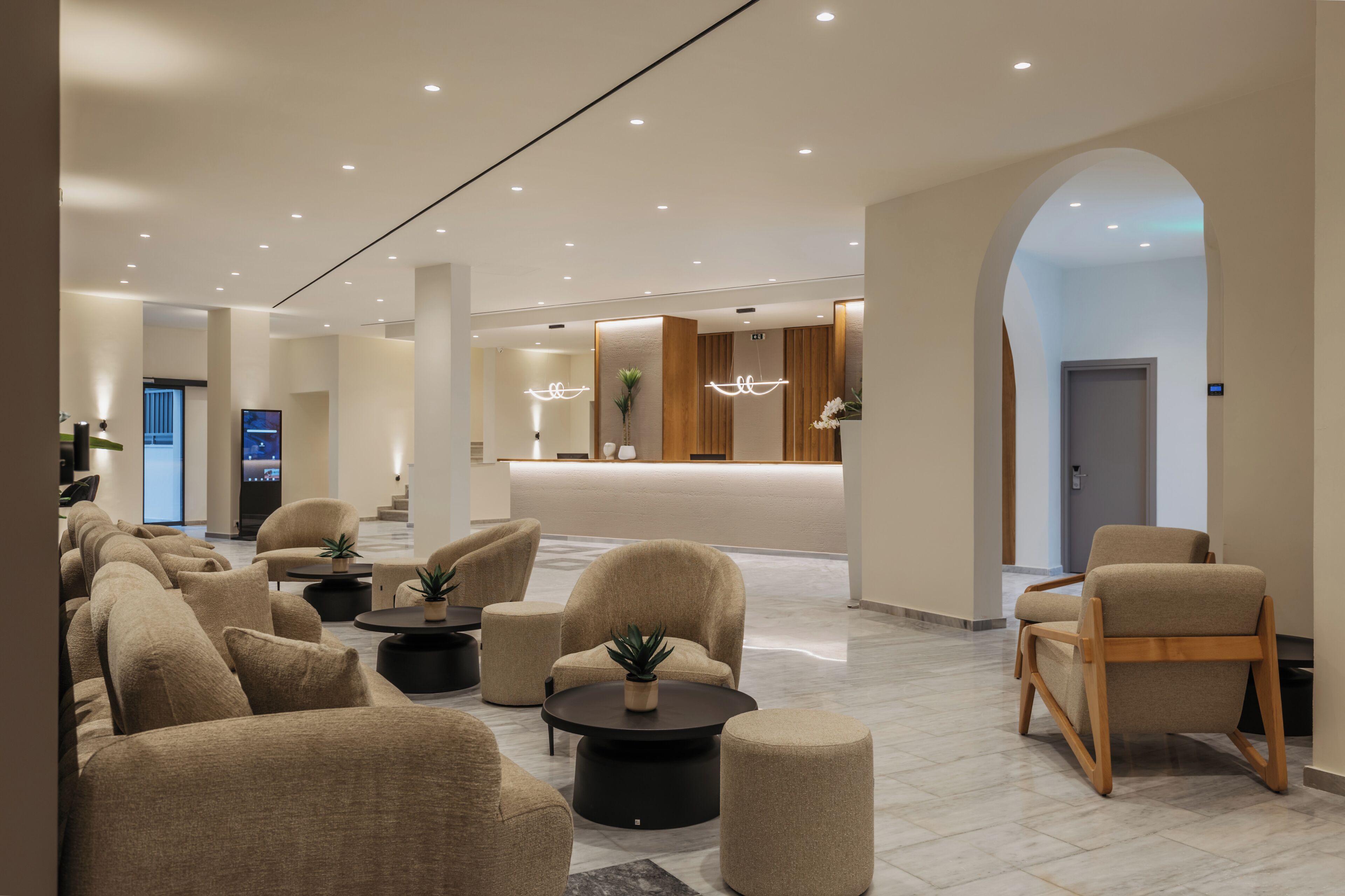 A modern lobby with sofas, round tables, and a reception desk.