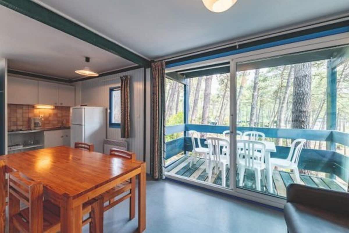 A modern kitchen with white cabinets and a wooden dining table.