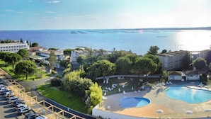 Un hotel con piscina, estacionamiento y vistas al mar.