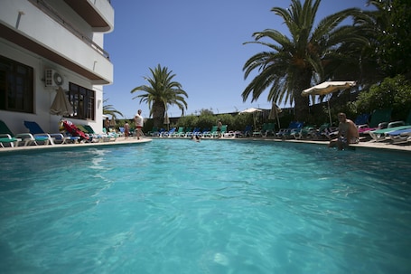 Alberca al aire libre y camastros