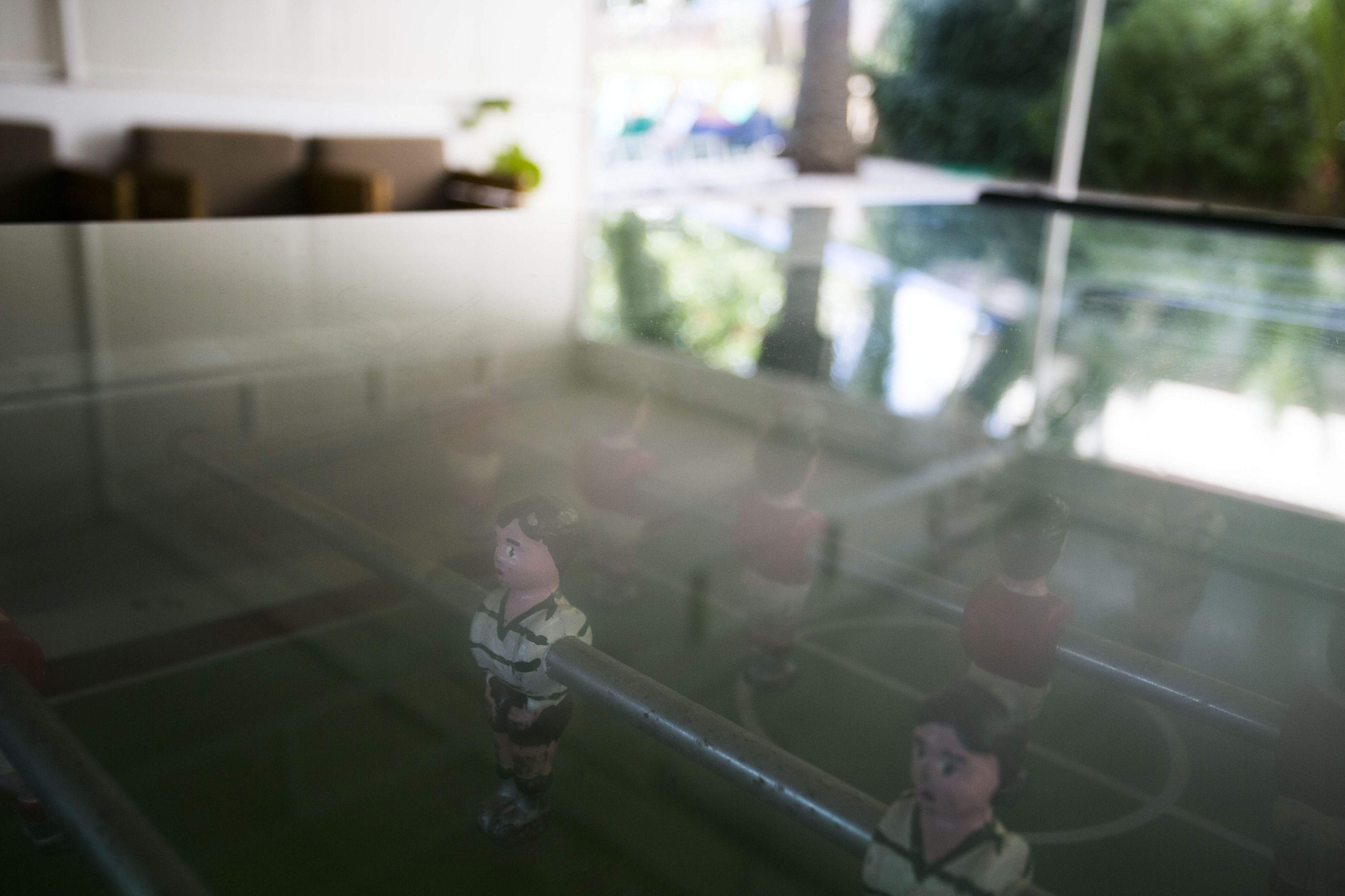A glass table with a reflection of a person standing.