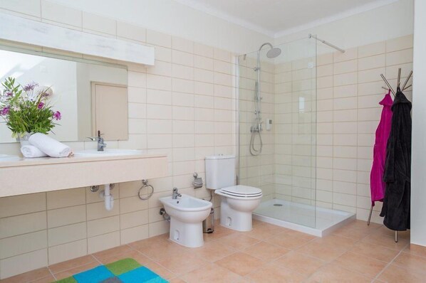 A modern bathroom with a shower, bidet, toilet, and sink. - Colina da Lapa & Villas (Lagoa)